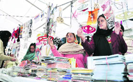 women purchase religious banners at a makeshift stall.