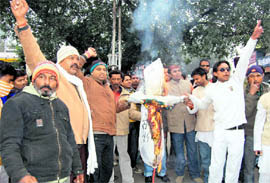 Youth Congress workers burn an effigy of the state government at Clock Tower in Dehradun on Tuesday