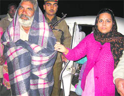 An old man wraps a blanket presented by Deputy Commissioner Amneet P Kumar in Kaithal on Monday night.