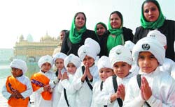 Children, who participated in the nagar kirtan to mark the 344th birth anniversary of Guru Gobind Singh, pay obeisance at the Golden Temple in Amritsar 