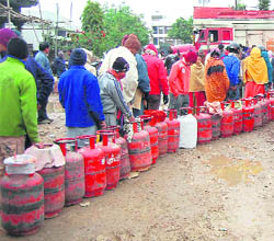 Customers queue up to get a refill of LPG cylinders in Dehradun on Wednesday.