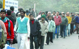 Metro passengers queue up at the Pragati Maidan Station in New Delhi on Thursday.