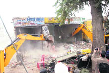 Structures on the Barnala bypass being demolished during a drive carried out by the Municipal Corporation in Bathinda on Thursday. 