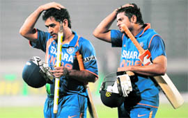 Indian cricket team captain MS Dhoni (L) and Suresh Raina walk off the pitch after beating Bangladesh in Dhaka on Thursday.
