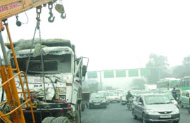 A loaded truck hit a pillar due to thick fog near the Moolchand flyover in New Delhi on Friday.