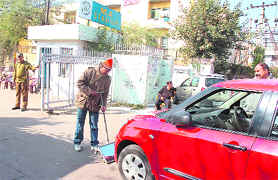 A securityman checks a car outside the MA Stadium in view of the Republic Day celebrations in Jammu on Friday. 