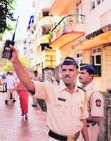 Policemen at the gate of the Swastik Court after an incident of firing by some unidentified persons in Mumbai