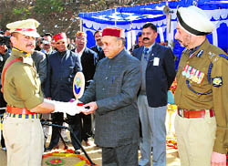 Chief Minister Prem Kumar Dhumal honouring the best police employee during the passing-out parade at the police training centre at Daroh, about 45 km from Dharamsala, on Saturday
