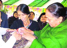 Uttarakhand Governor Margaret Alva administers polio drops to an infant at the Raj Bhawan in Dehradun