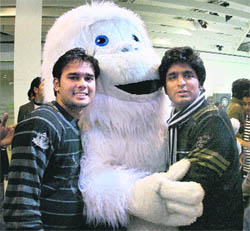 Visitors pose with a man dressed up as Yeti at the 10th Auto Expo in New Delhi on Monday. Skoda has unveiled a car by the name Yeti.