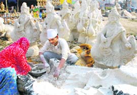 A couple makes idols of Goddess Saraswati in view of the fo