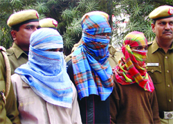 The Delhi police produces three men accused of murder and robbery in New Delhi on Monday.