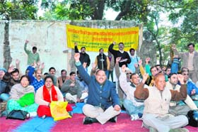 Employees of the Uttaranchal Federation of Ministerial Services Association stage a dharna at the Gandhi Road in Dehradun