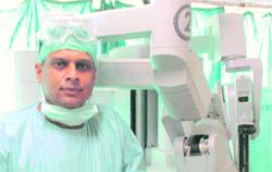Dr Sachit Sharma with a robotic arm machine used in advanced surgeries