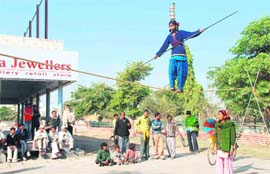 A girl performs a tightrope walk to earn a living in a busy Hisar market