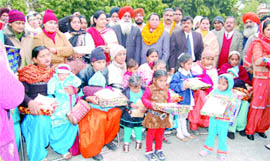 Girl children with their gifts presented to them at a state-level function to celebrate Lohri dedicated to girl child in Phagwara on Monday.