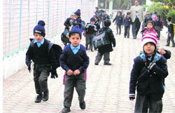 Tiny tots brave the cold as primary schools reopen after an extended winter break in Ludhiana on Monday.
