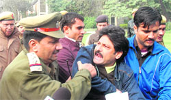 Cops whisk away a Kashmiri Pandit protesting against JKLF chief Yasin Malik in New Delhi.