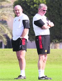 Manchester United coaches Alex Ferguson (R) and Mike Phelan attend a training session in Doha
