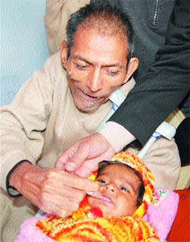 I wont let you suffer: A polio affected person administers polio drops to a child in Amritsar. 