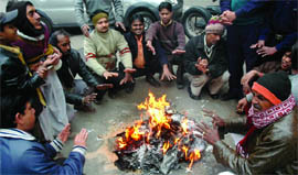 People huddle around a fire in New Delhi on Tuesday.