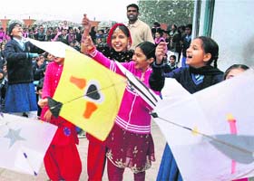 ALL SMILES: Schoolchildren fly kites on the eve of the Lohri festival