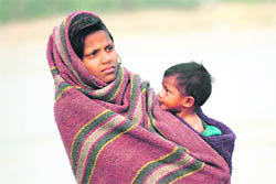 With a cold wave sweeping the region, this girl and her brother try to get some respite with a blanket. 