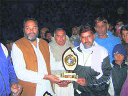 BJP leader Laxman Singh Yadav presents a trophy to a player at BKpur village in Rewari. Photos by the writer