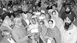 Punjab Parliamentary Secretary distributes cheques among villagers at Rajpura. 