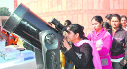 A girl watches solar eclipse through a telescope at Panjab University, Chandigarh, on Friday.