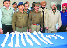 Police officials display weapons seized from the robbers at the crime branch in Sector 11, Chandigarh, on Friday.