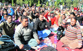 Members of the Uttaranchal Federation of Ministerial Service Association stage a dharna at the Gandhi Park in Dehradun on Friday