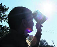 A man watches, using a screen, solar eclipse at Dharamsala on Friday.