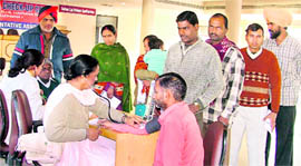 Migrant labourers being examined at a medical check-up camp in Ludhiana on Friday.