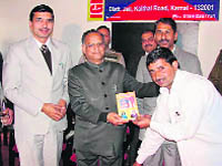 Sessions Judge Vinod Jain distributing books of the Bachelors Priority Programme by IGNOU at district jail in Karnal on Friday. Jail superintendent Jagjit Singh is also seen in the picture.