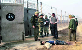 BSF and police officers examine the scene in the RS Pura sector where an intruder from Pakistan was shot dead .