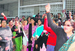 Workers of the Mahila Congress Wing hold a protest in front of the office of the Dehradun District Magistrate on Monday. 
