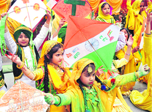 Children dress up in yellow attire and show tricolour kites on the eve of Basant Panchami at DAV Public School in Patiala on Tuesday. 