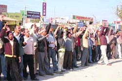Shiksha Acharyas cheer their leader who is atop a Doordarshan tower in Dehradun 