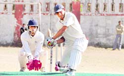 A batsman prepares to play a shot during a match of the 58th District Cricket League in Dehradun