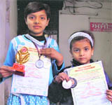 Sanjivni and Promila show their medals and certificates after winning the yoga championship in Ludhiana.