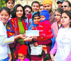 Students of DAV College, Sector 10, hand over a cheque for Rs 50,000 to Rajwinder Kaur in Chandigarh on Wednesday. 