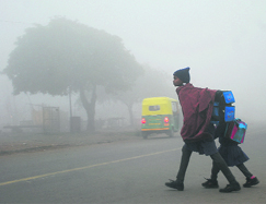 Two girls walk to school in dense fog in Mohali on Thursday. 