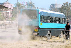 A bus moves about raising dust at the Parade Ground in Dehradun