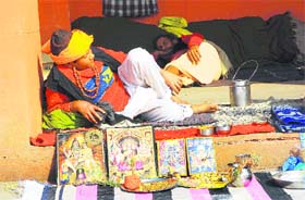 A pandit waits for customers on the banks of Brahmasarovar in Kurukshetra