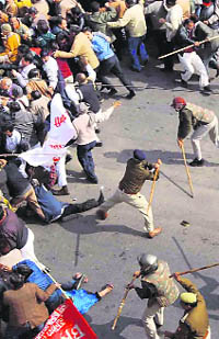 Policemen cane-charge government staffers during a salary-related protest in Lucknow on Thursday.