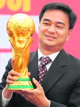 Thai Prime Minister Abhisit Vejjajiva holds the FIFA World Cup trophy during a promotional event in Bangkok