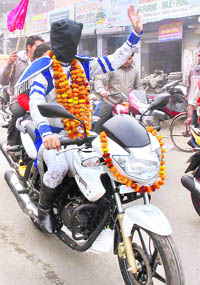Blind- folded magician Samrat Mangal Tara rides a motorcycle in Karnal on Friday. 