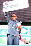 Ethiopia's Mamitu Daska Molisa celebrates by raising the winner's cheque after winning the Dubai Marathon on Friday
