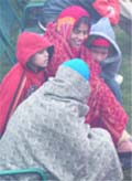 Women and children wrap themselves up to escape the chill in New Delhi